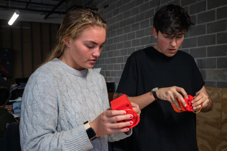 SWARM members Christena Berry (left) and Harrison Felipe work on their modular robots. The team is composed of electrical, mechanical and software engineering students. (Photo: Sid Hastings/WashU)