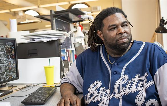 Ryan A. Wilson, a master’s candidate in architecture and construction management at the Sam Fox School of Design & Visual Arts, sits at his desk in Givens Hall. (Photo: Carol Green/Washington University)