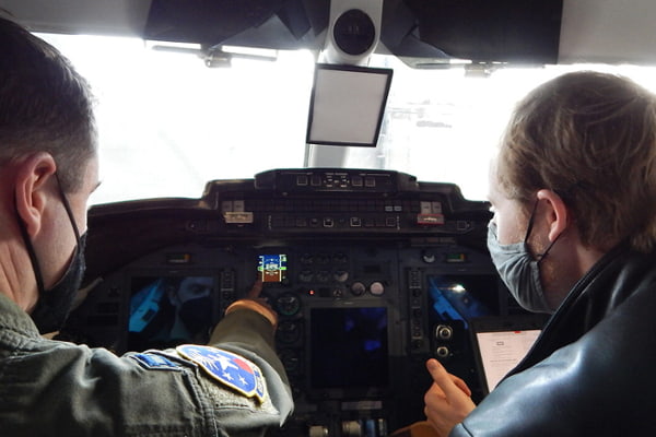 C-21 pilot Capt. Chandler Thorpe (left), 458th Airlift Squadron, and Washington University graduate student Kyle Gero go through a pre-flight checklist. Gero is collaborating with Scott’s Elevate innovation team and the squadron on a C-21 cockpit trainer project.