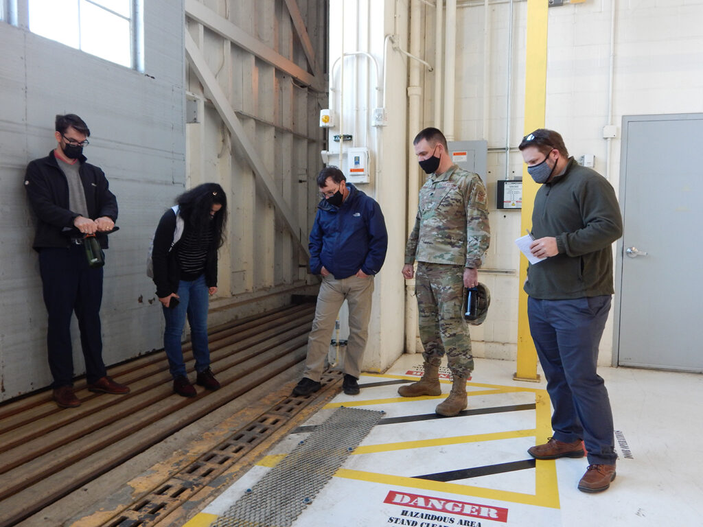 Washington University graduate students (from left) Kyle Collier, Astha Bhatnagar and Cam Loyet talk with Lt. Col. Paul Fredin