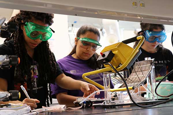 High school students use photovoltaic panels to produce fuel to power toy cars. Nearly two dozen students visited campus to learn more about thermodynamics.