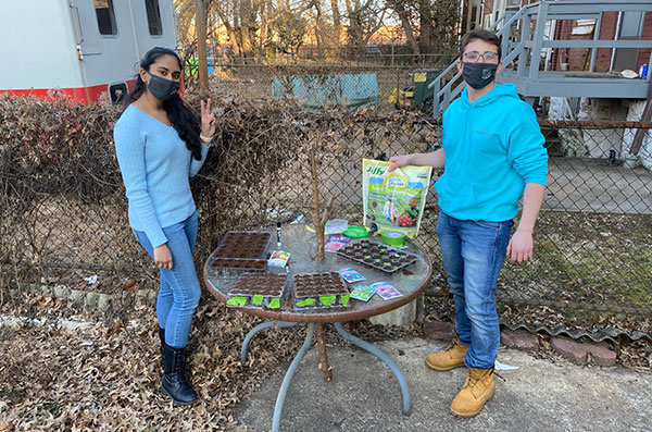 From left, Keya Nagula, oSTEM secretary, and Dean Oken, oSTEM president, plant flowers during an event that will later be given to students during oSTEM’s May social event. Submitted photo 